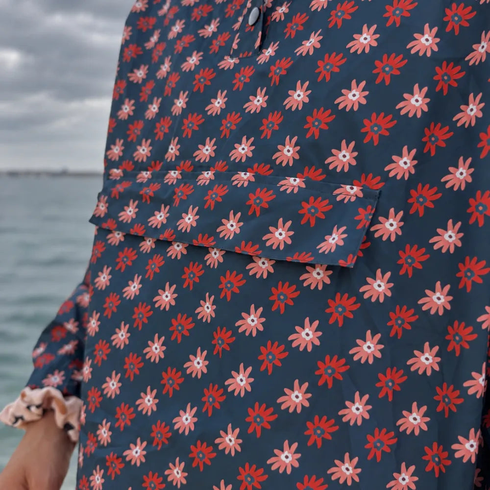 Détail de la matière imperméable du poncho Paola à motifs marguerites