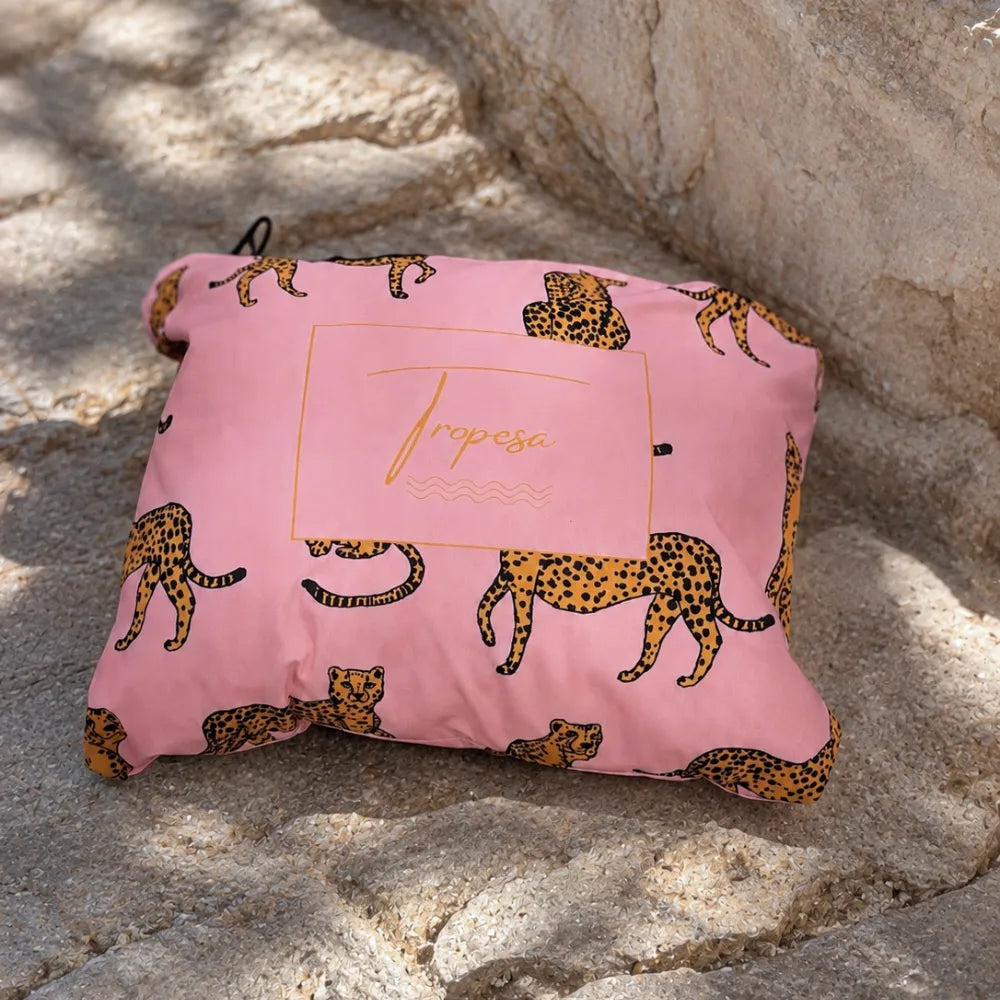 Poncho de pluie Alexie rose à motifs léopard plié dans sa pochette