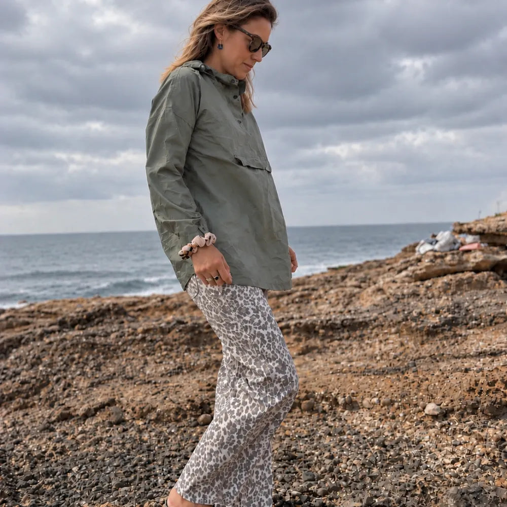 Poncho imperméable kaki porté par temps pluvieux avec capuche