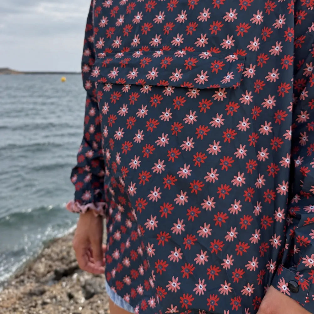 Vue de face du poncho de pluie Paola bleu marine à motifs marguerites