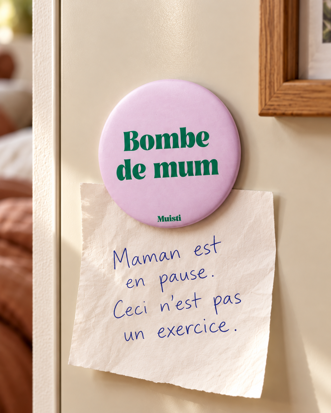 Magnet Muisti « Bombe de mum » tenant un petit mot dans une scène du quotidien.