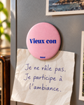 Magnet Muisti « Vieux con » tenant un petit mot sur un tableau magnétique.