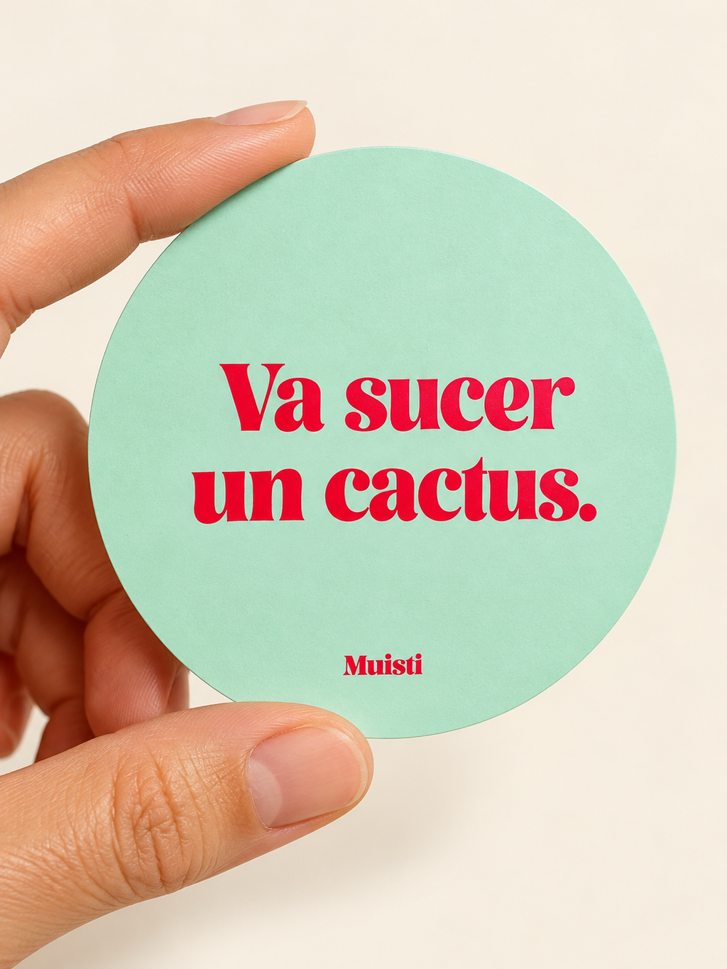 Sticker Muisti Va sucer un cactus. tenu entre le pouce et l’index sur fond ivoire