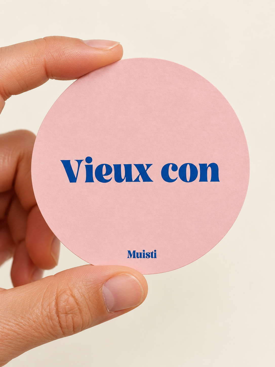 Sticker Muisti Vieux con tenu entre le pouce et l’index sur fond ivoire